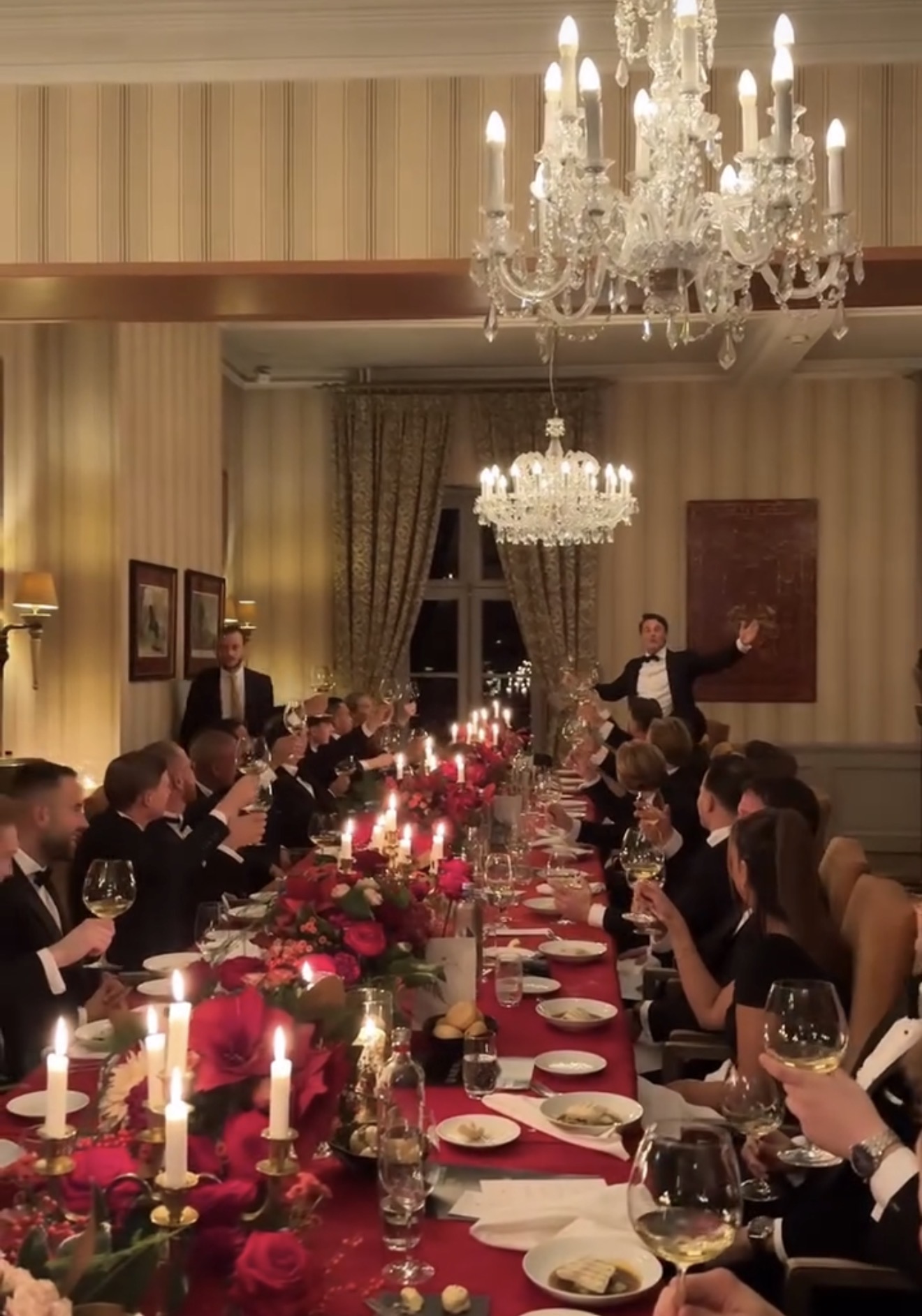 Gasten heffen hun glas tijdens een diner aan tafel